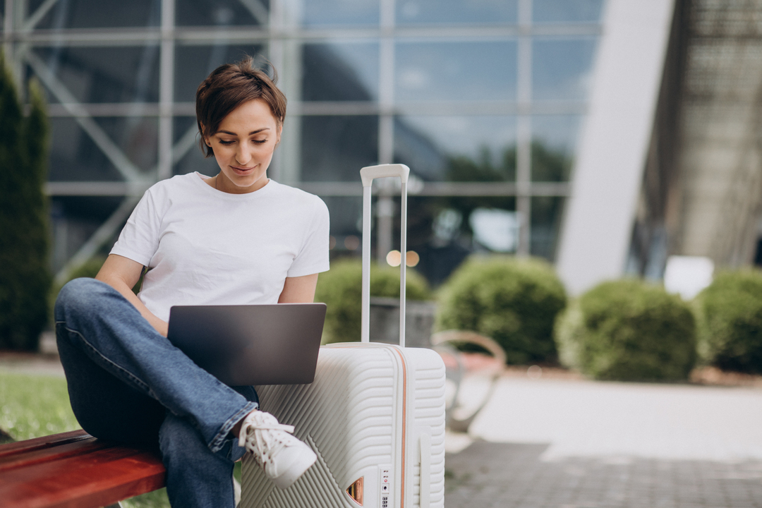 Viagem a trabalho: imaem mostra mulher viajando e trabalhando no computador no aeroporto