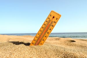 Onda de calor: imagem mostra termômetro em uma praia, demonstrando elevação de temperatura.